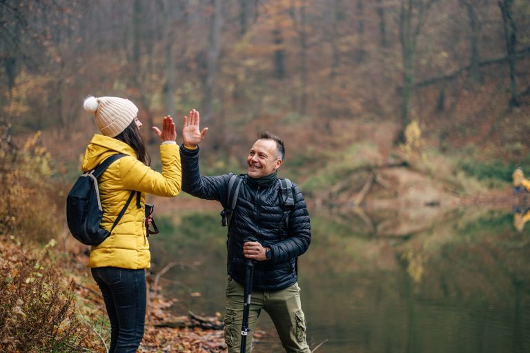 Caucasian man and woman, beating the top of the mountain, after a long hike.